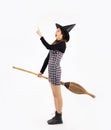 Halloween theme, young pretty asian girl in black dress wearing witch hat and holding broom posing finger pointing and touching on Royalty Free Stock Photo