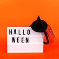 Halloween themed cinema light box on the bright orange background with funny witch hat Royalty Free Stock Photo