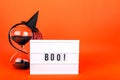 Halloween themed cinema light box on orange background with funny witch hat and black sand hourglass Royalty Free Stock Photo