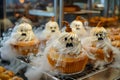 Halloween Themed Cupcakes Decorated with Ghostly Faces and Pretzel Stems in a Bakery Display Royalty Free Stock Photo