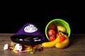 Halloween treats coming out of a bucket next to fruit coming out of another bucket