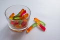 Halloween treats gummy worms in glass. Colorful jelly candies on white background. Top view Royalty Free Stock Photo