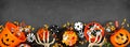 Halloween trick or treat bottom border with jack o lantern pails and mixed candy on a black banner background Royalty Free Stock Photo