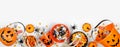 Halloween trick or treat bottom border with jack o lantern pails and a variety of candy on a white banner background Royalty Free Stock Photo
