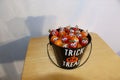 A halloween trick or treat bucket full of worried looking baby tomatoes