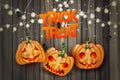 Halloween trick or treat realistic design. Haning pumpkins and lights garland over wooden board background. Royalty Free Stock Photo