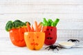 Halloween vegetables and dip in Jack o Lantern peppers on white wood Royalty Free Stock Photo