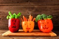 Halloween vegetables and dip in Jack o Lantern peppers on a wood background Royalty Free Stock Photo