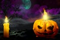 Halloween vivid haunting dark night backdrop - lone candle on left side and candle in pumpkin style on the right, holiday concept