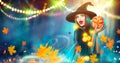 Halloween witch with a carved pumpkin and magic lights Royalty Free Stock Photo