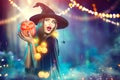 Halloween. Witch with a carved pumpkin and magic lights Royalty Free Stock Photo