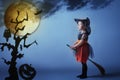 Halloween. Witch child flying on broomstick at sunset night sky. Royalty Free Stock Photo