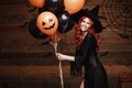 Halloween Witch Concept - Beautiful caucasian woman in witch costumes celebrating Halloween posing with posing with orange and bla Royalty Free Stock Photo