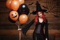 Halloween Witch Concept - Beautiful caucasian woman in witch costumes celebrating Halloween posing with posing with orange and bla Royalty Free Stock Photo