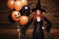 Halloween Witch Concept - Beautiful caucasian woman in witch costumes celebrating Halloween posing with posing with orange and bla Royalty Free Stock Photo