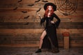 Halloween witch concept - Full-length Happy Halloween red hair Witch holding posing with magic broomstick over old wooden studio b