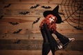 Halloween witch concept - Happy Halloween red hair Witch holding magic broomstick flying gesture over old wooden studio background