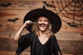 Halloween Witch concept - little witch child enjoy playing with magic wand. over bat and spider web background. Royalty Free Stock Photo