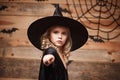 Halloween Witch concept - little witch child enjoy playing with magic wand. over bat and spider web background. Royalty Free Stock Photo