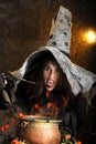 Halloween witch cooking in a copper cauldron