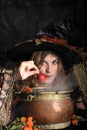 Halloween witch cooking in a copper cauldron