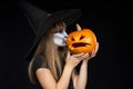 Halloween witch girl giving a kiss to Jack-O-Lantern pumpkin Royalty Free Stock Photo
