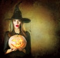 Halloween Witch holding carved pumpkin Jack Lantern