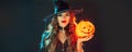 Halloween Witch holding Pumpkin lantern over black background. Decoration, hanging Jack-o-Lantern Pumpkin Royalty Free Stock Photo