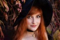 Halloween Witch redhead woman making witchcraft with magic Book of spells, magic in her hands Royalty Free Stock Photo