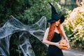 Halloween Witch redhead woman making witchcraft with magic Book of spells, magic in her hands. Royalty Free Stock Photo