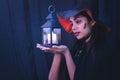 Halloween witch woman portrait holding candle lamp, fashion young woman going to party with spooky costume, makeup scary faces,