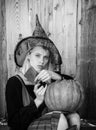 Halloween woman. Attractive witch holding pumpkin and knife for a `trick or treat`. Black and white. Royalty Free Stock Photo