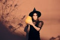 Halloween Woman in Witch Costume Holding Pumpkin