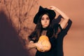 Halloween Woman in Witch Costume Holding Pumpkin