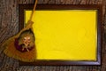 Halloween. Wooden frame with web and yellow paper blank space for text with witch toy on broom. List for recording Royalty Free Stock Photo