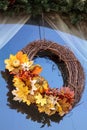 Halloween wreath with fall leaves and pumpkin hangs in a window Royalty Free Stock Photo