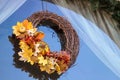 Halloween wreath with fall leaves and pumpkin hangs in a window Royalty Free Stock Photo