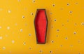 Halloween yellow background with an open red-black coffin in the center, around a scattering of plastic eyes of different sizes. A