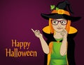 Halloween. A young girl in a hat and a witch costume points thou Royalty Free Stock Photo