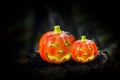 Hallowen pumpkins with shining eyes on a wooden block. Inside has a lighted candle