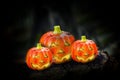 Hallowen pumpkins with shining eyes on a wooden block. Inside has a lighted candle