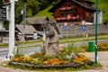 Hallstatt, Austria, 27 August 2021: stone statue of salt miner Colorful scenic picturesque town street at summer day, mountain