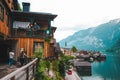 Hallstatt, Austria - June 15, 2019: elder people talking from the balcony with young couple