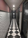 Hallway with a black and white floor and doors under the lamp lights Royalty Free Stock Photo