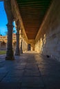 Hallway of the cloister of the University of Salamanca with the columns and arches projected on the wall to the exit door by the