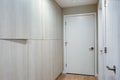 Hallway features ivory cabinets and taupe walls