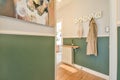 a hallway with a green wall and a coat rack