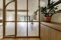 Hallway of a home with an antechamber with glass and wood display cabinets, interior floors and a large empty living room in the