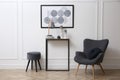 Hallway with stylish console table and armchair. Interior Royalty Free Stock Photo