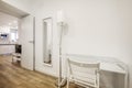 Hallway of a vacation rental home with a white glass-topped study table along with a white wooden folding chair